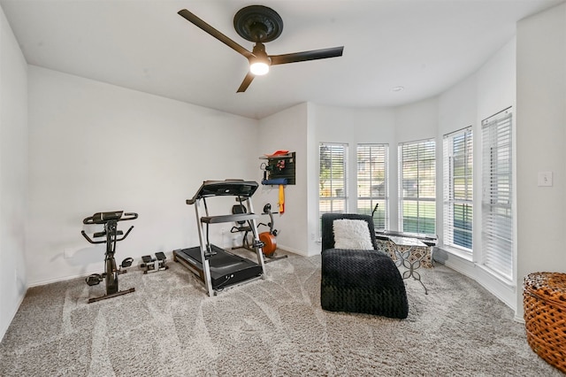 workout room with ceiling fan and light colored carpet