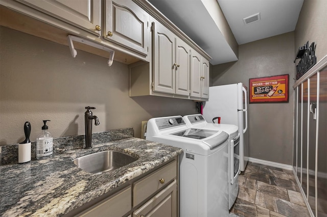 washroom with cabinets, sink, and washer and dryer