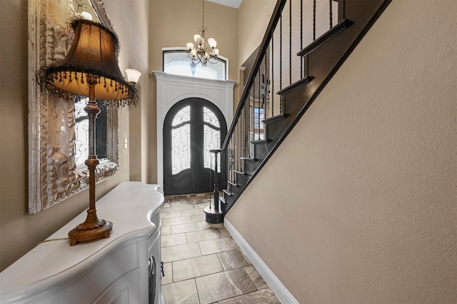 foyer entrance featuring french doors and an inviting chandelier