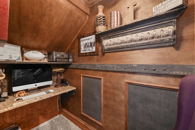 interior space featuring built in desk, vaulted ceiling, and stone countertops