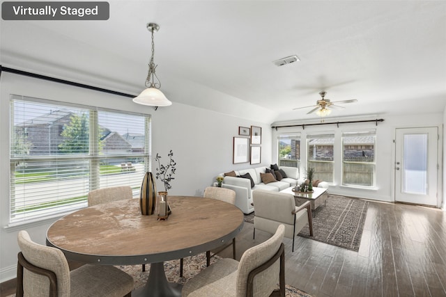 dining area with ceiling fan, vaulted ceiling, and dark hardwood / wood-style flooring