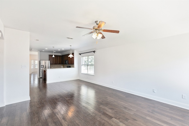 unfurnished living room with dark hardwood / wood-style flooring and ceiling fan