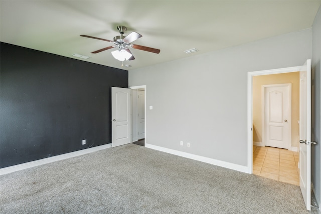 carpeted empty room featuring ceiling fan