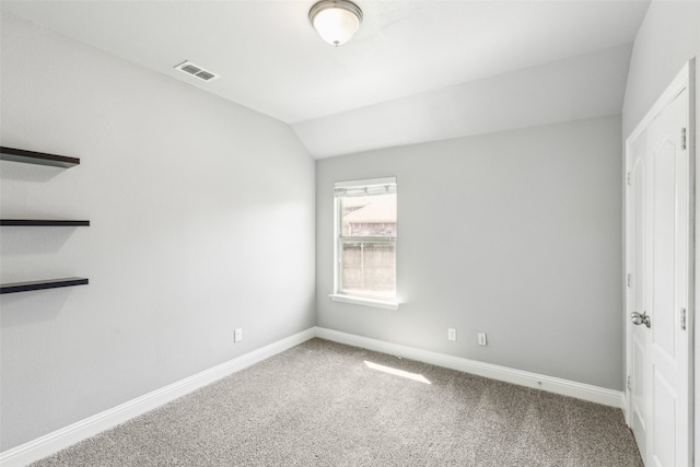 unfurnished bedroom with carpet flooring and vaulted ceiling