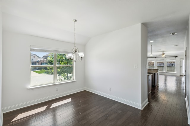 spare room featuring ceiling fan with notable chandelier, dark wood-type flooring, lofted ceiling, and a wealth of natural light