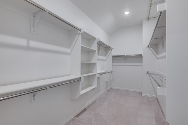 spacious closet with light colored carpet and lofted ceiling