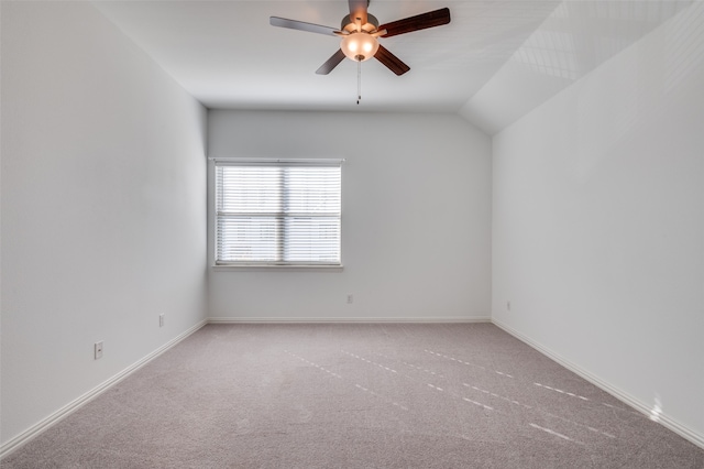 spare room with vaulted ceiling, ceiling fan, and light colored carpet