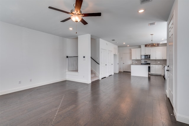 unfurnished living room featuring ceiling fan and dark wood-type flooring