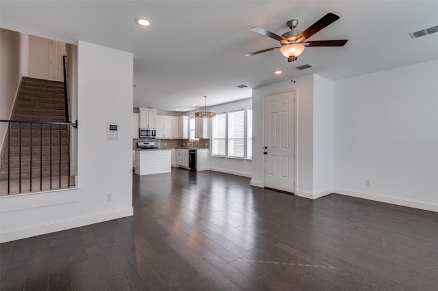 unfurnished living room with ceiling fan and dark hardwood / wood-style flooring