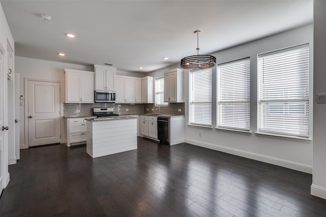 kitchen featuring decorative light fixtures, white cabinetry, dishwasher, white stove, and dark hardwood / wood-style flooring