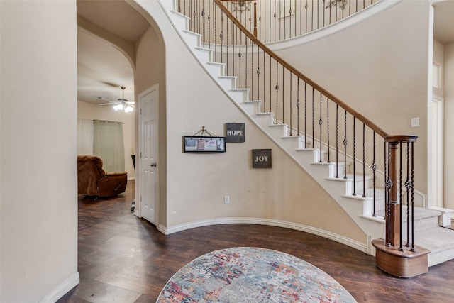 staircase with hardwood / wood-style floors, ceiling fan, and a high ceiling