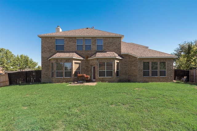 back of property with a lawn and a patio area