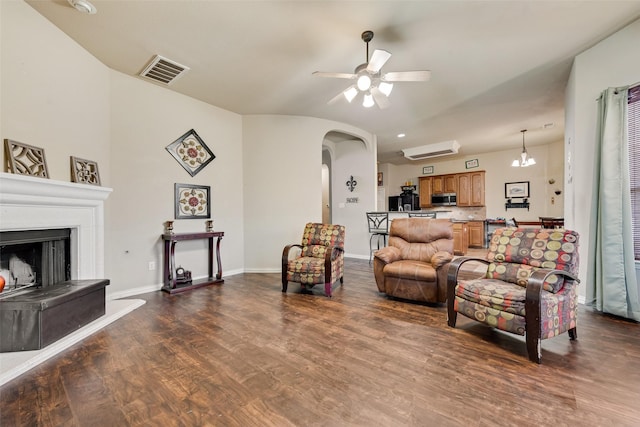 living room featuring dark wood-type flooring and ceiling fan with notable chandelier