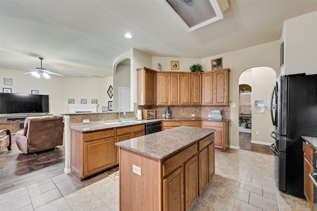 kitchen featuring ceiling fan, sink, a center island, kitchen peninsula, and black appliances