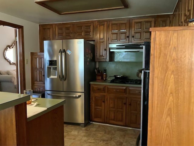 kitchen featuring fridge, backsplash, stainless steel fridge with ice dispenser, and gas cooktop