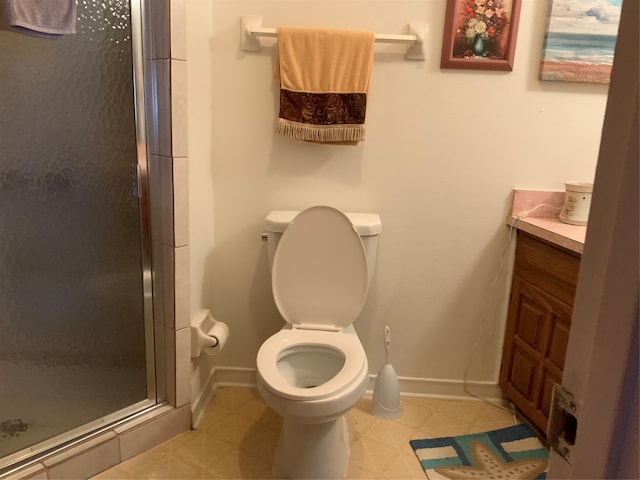 bathroom featuring vanity, a shower with shower door, and toilet