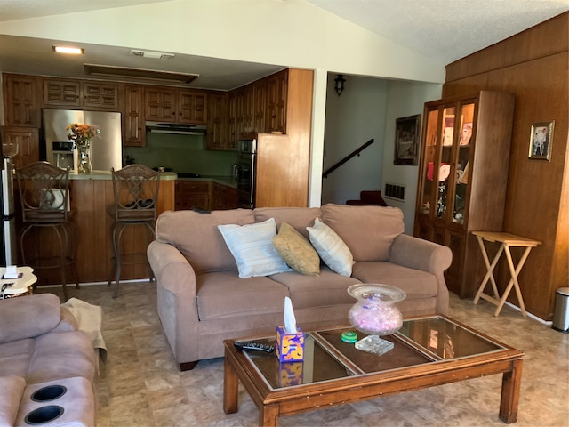 living room with wooden walls and lofted ceiling