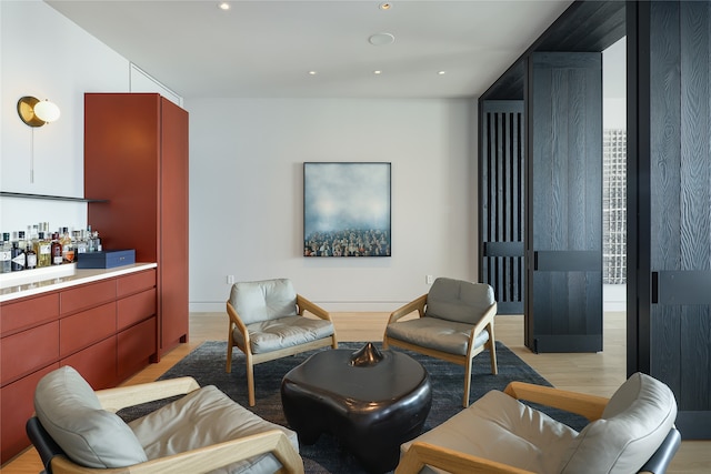 living room with light hardwood / wood-style floors and indoor bar