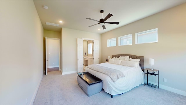 carpeted bedroom featuring ensuite bath and ceiling fan