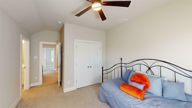 bedroom with ceiling fan, lofted ceiling, light carpet, and a closet