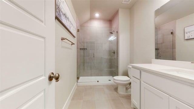 bathroom featuring vanity, a shower with door, vaulted ceiling, tile patterned flooring, and toilet