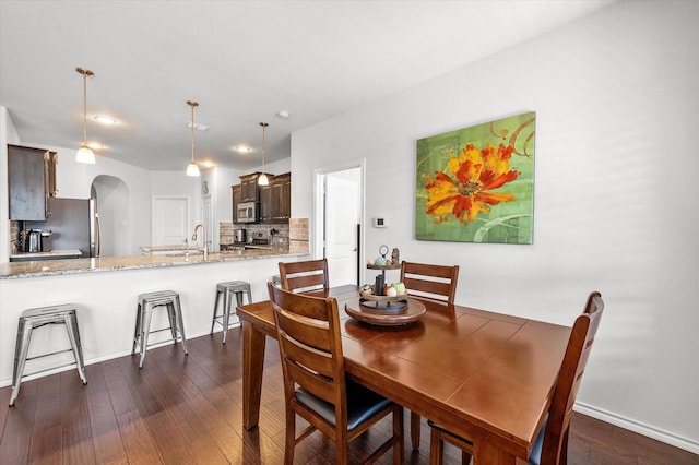 dining space featuring dark hardwood / wood-style floors and sink