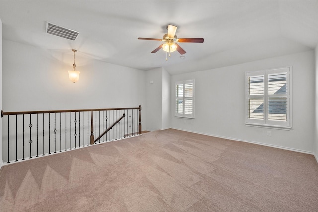 carpeted spare room featuring ceiling fan