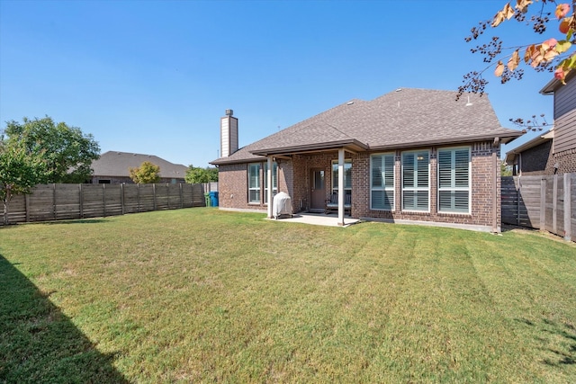 back of property featuring a lawn and a patio