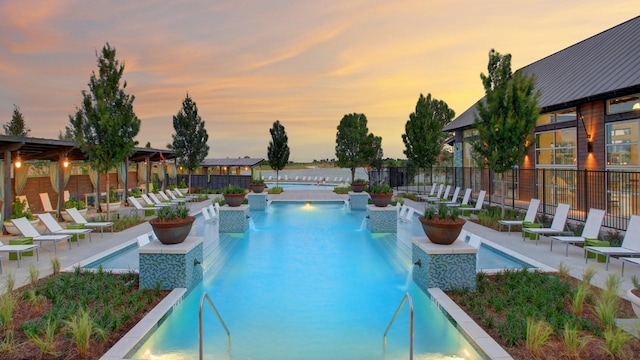 pool at dusk featuring pool water feature