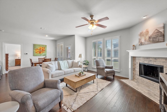 living room with ceiling fan, dark hardwood / wood-style floors, and a fireplace