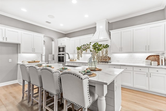 kitchen featuring white cabinets, a center island with sink, sink, and stainless steel appliances