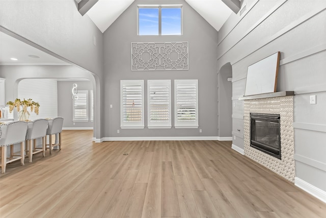 living room featuring light wood-type flooring and high vaulted ceiling