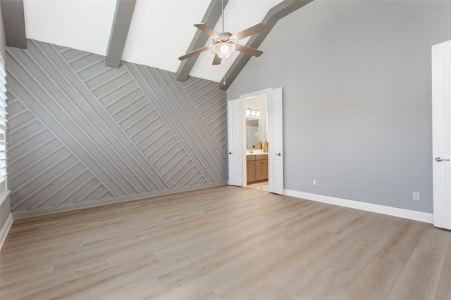 interior space with ceiling fan, beamed ceiling, wooden walls, high vaulted ceiling, and light hardwood / wood-style floors