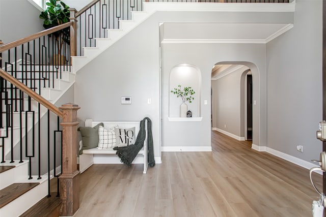 foyer with light hardwood / wood-style flooring and crown molding