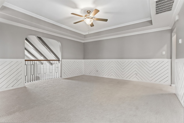 unfurnished room with ornamental molding, ceiling fan, a raised ceiling, and carpet flooring