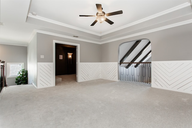 unfurnished room featuring ceiling fan, a raised ceiling, crown molding, and carpet