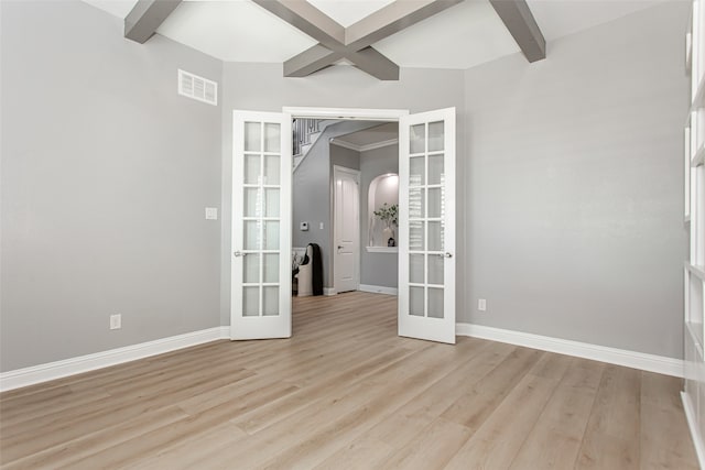 empty room with french doors, beamed ceiling, and light wood-type flooring