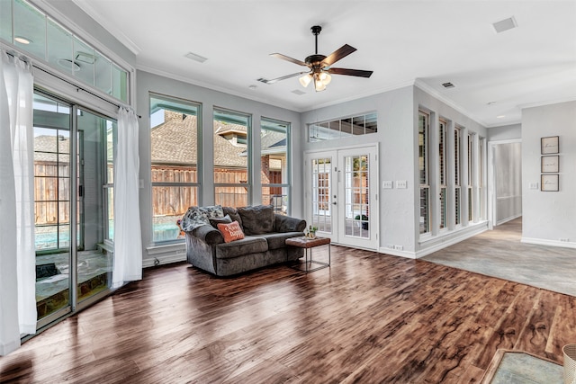 living room with ornamental molding, a wealth of natural light, ceiling fan, and dark hardwood / wood-style flooring