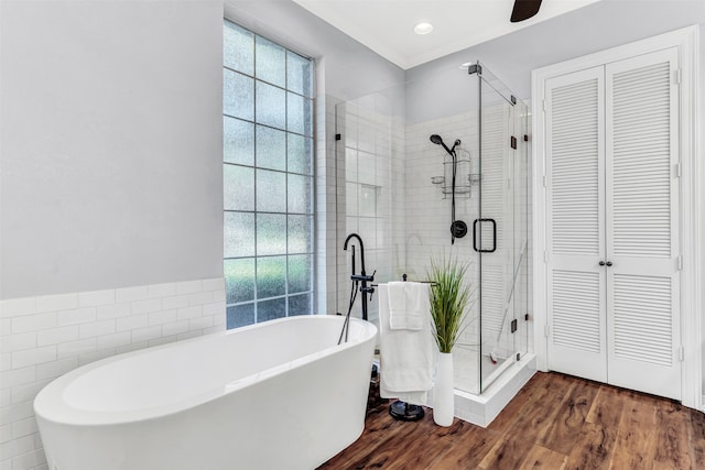 bathroom with tile walls, wood-type flooring, separate shower and tub, and crown molding