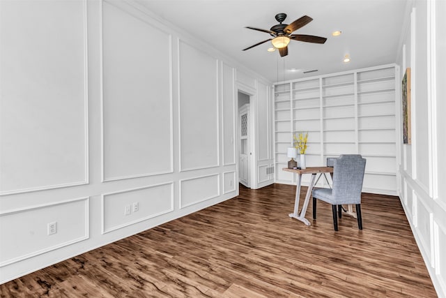 home office with built in shelves, hardwood / wood-style floors, ceiling fan, and crown molding