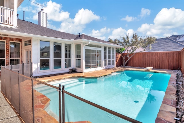 view of swimming pool featuring a diving board