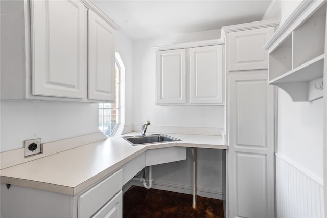 interior space with sink, electric dryer hookup, and cabinets