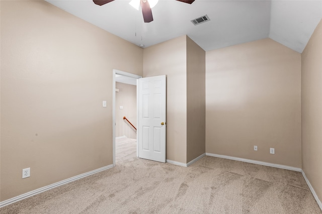 empty room with ceiling fan, light colored carpet, and vaulted ceiling