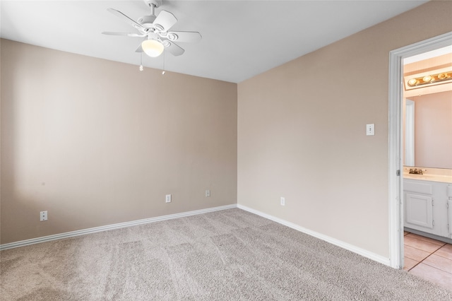 unfurnished room with sink, ceiling fan, and light colored carpet