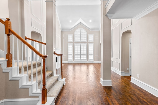 entryway featuring lofted ceiling, dark hardwood / wood-style floors, and crown molding