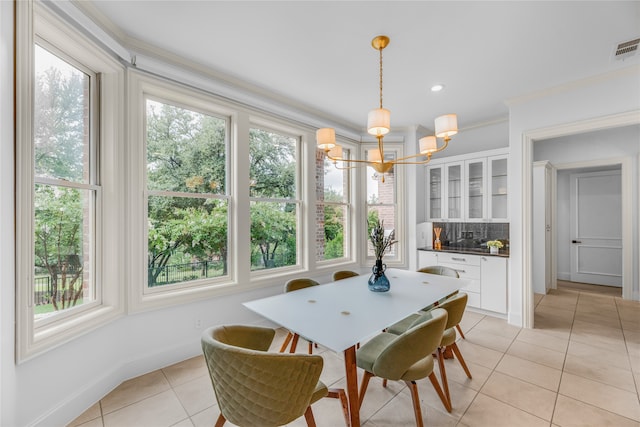 dining room featuring light tile patterned floors, a healthy amount of sunlight, and crown molding