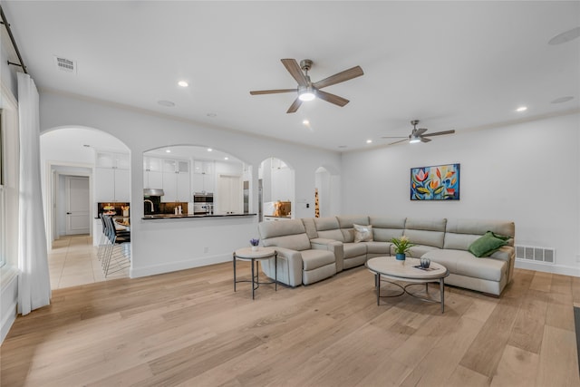 living room with ceiling fan and light hardwood / wood-style flooring