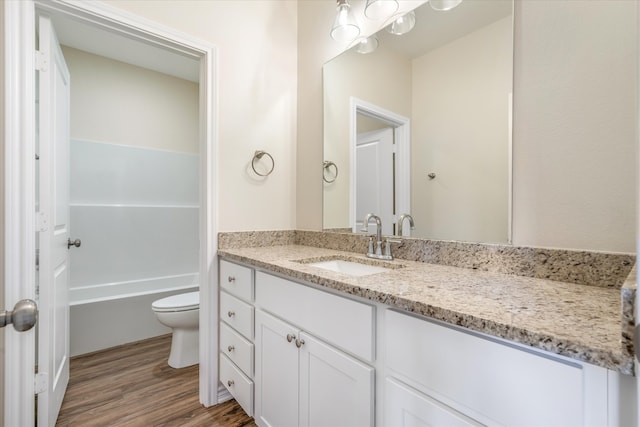 bathroom with wood-type flooring, vanity, and toilet