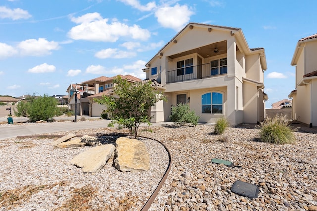 view of front of home featuring ceiling fan and a balcony