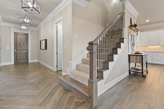 entrance foyer with wood-type flooring, crown molding, and a notable chandelier